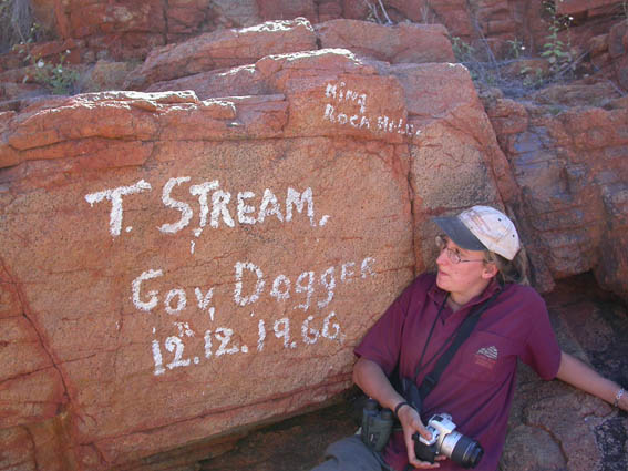 Photo showing Emma looking at painted words on a rock at King Rockhole